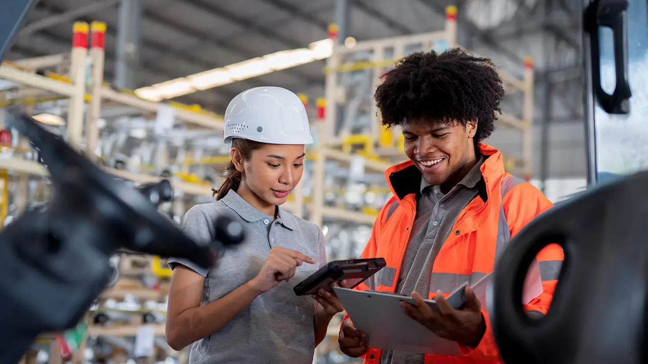 Factory workers confer about data.